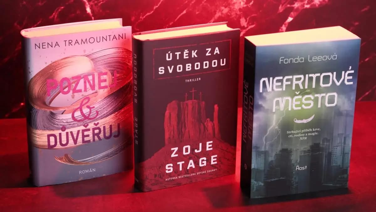 tři knihy vyfocené vedle sebe na černém pozadí s červeným světlem