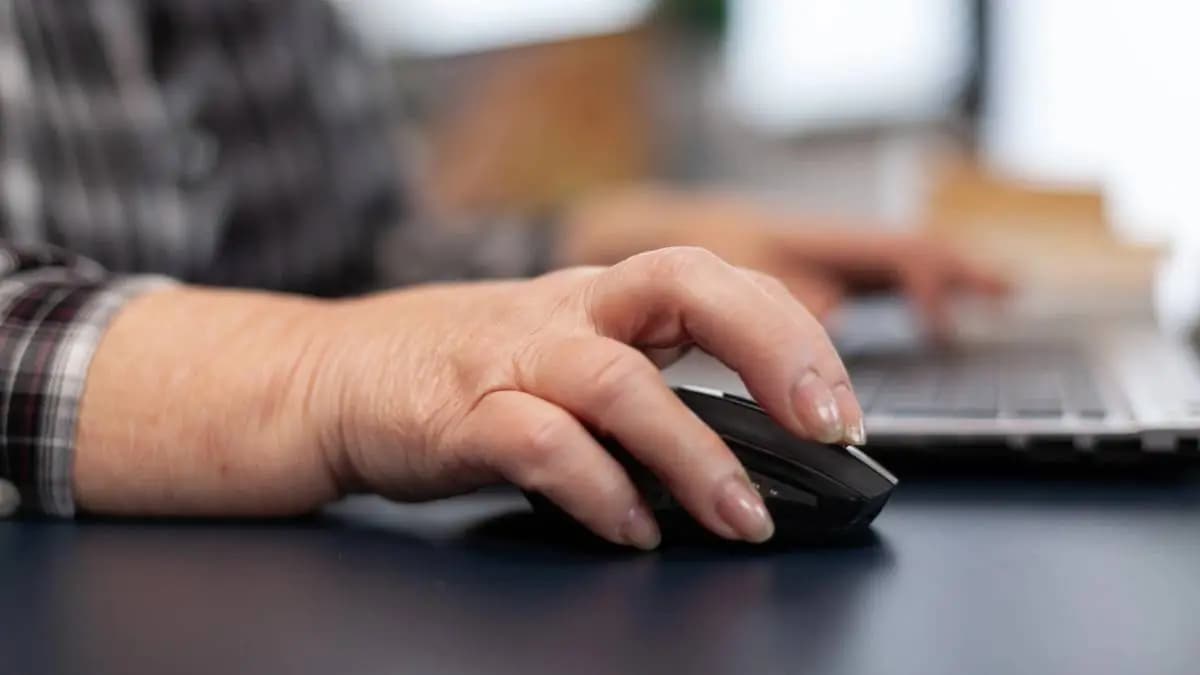 muž pracuje na pc, detail na myš a jeho ruku