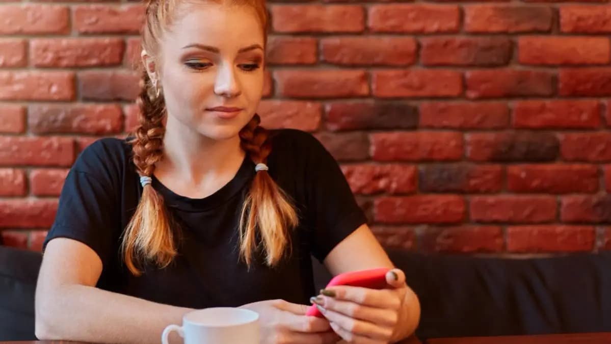 dívka si s někým píše na mobilu, ale už jí to nebaví
