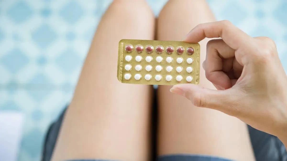 dívka drží v ruce platíčko s léky