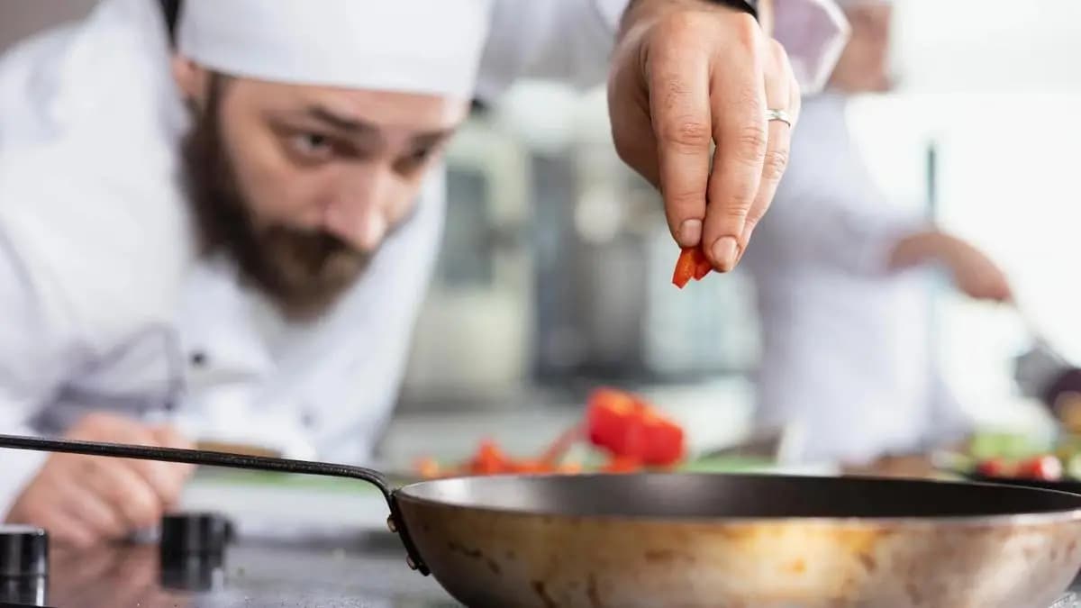 kuchař v kuchyni kouzlí s chilli papričkami