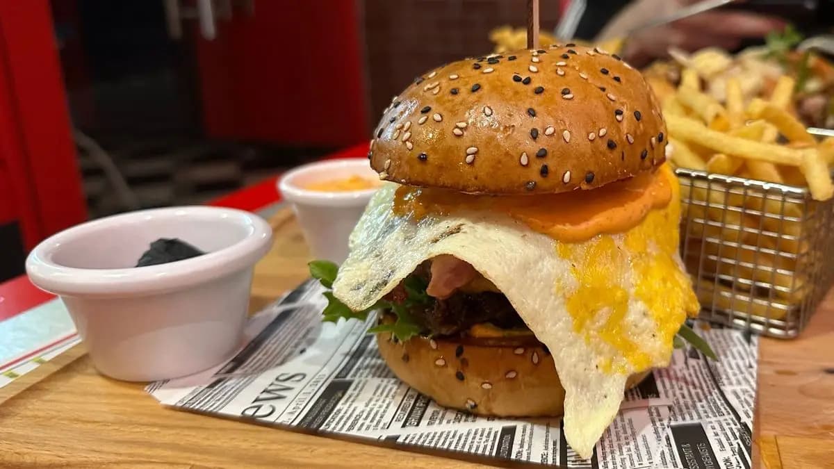 burger na stole, za ním hranolky burger na stole, za ním hranolky