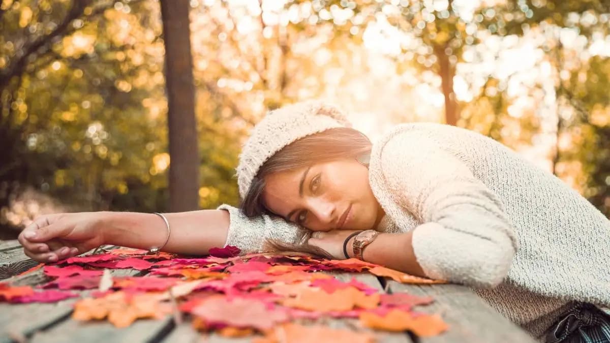žena se opírá o dřevěný stůl v parku, během západu slunce žena se opírá o dřevěný stůl v parku, během západu slunce