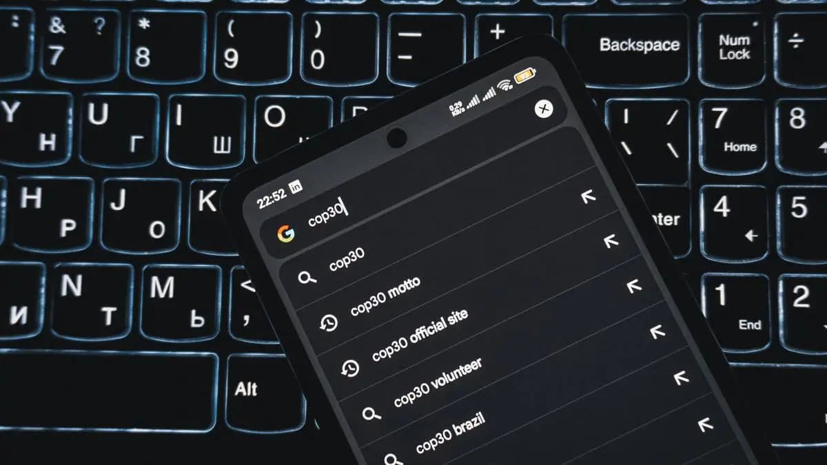 dark mode na mobilu, který je položen na klávesnici laptopu dark mode na mobilu, který je položen na klávesnici laptopu