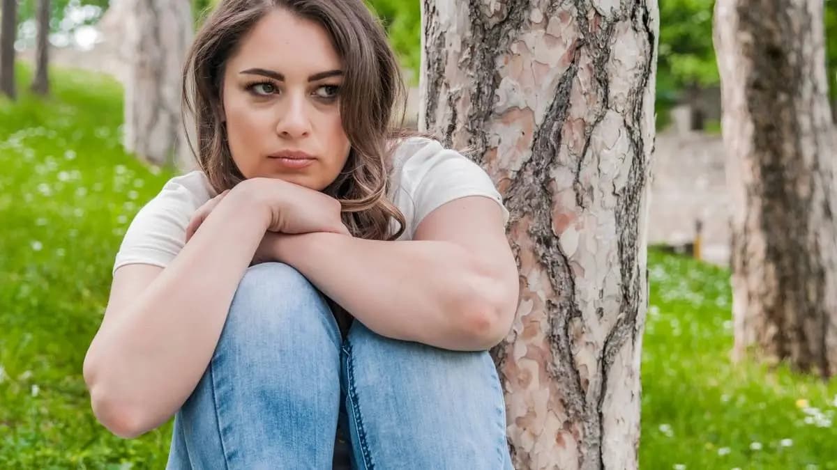 ubrečená dívka sedí v parku u stromu ubrečená dívka sedí v parku u stromu