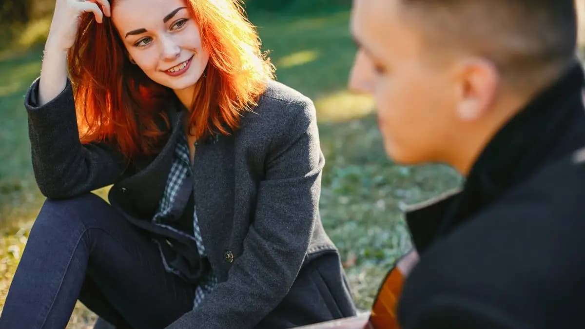 žena se dívá na muže, který hraje na kytaru žena se dívá na muže, který hraje na kytaru