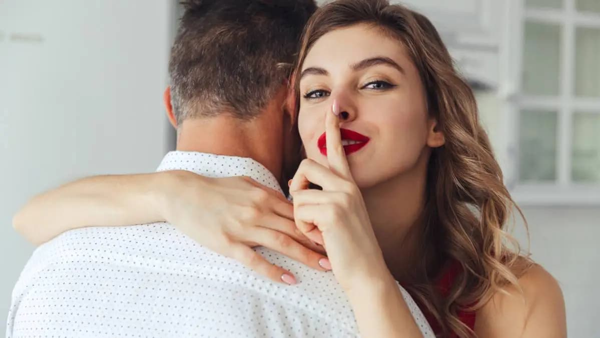 žena objímá muže a ukazuje, že má tajemství žena objímá muže a ukazuje, že má tajemství