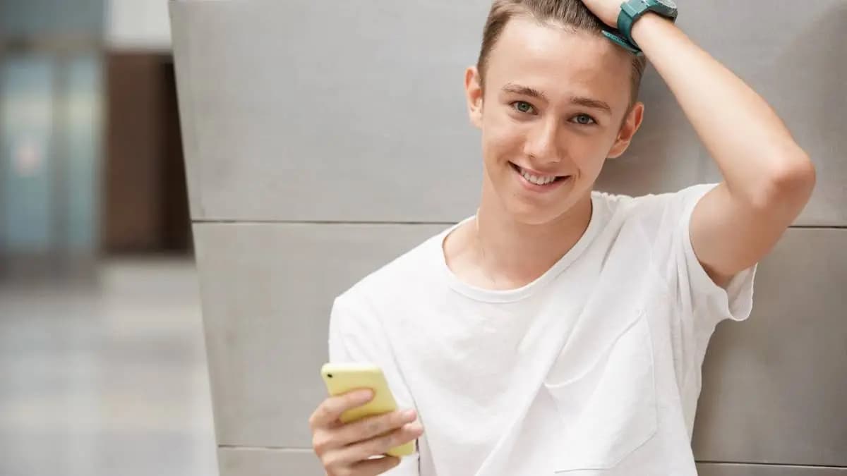 chlapec s mobilem opřený o stěnu chlapec s mobilem opřený o stěnu
