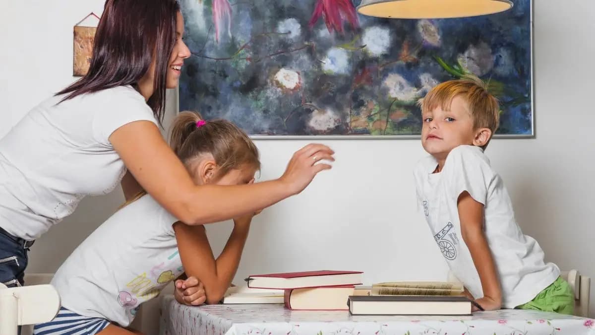 matka a dvě děti doma u stolu, kde jsou položené knihy matka a dvě děti doma u stolu, kde jsou položené knihy