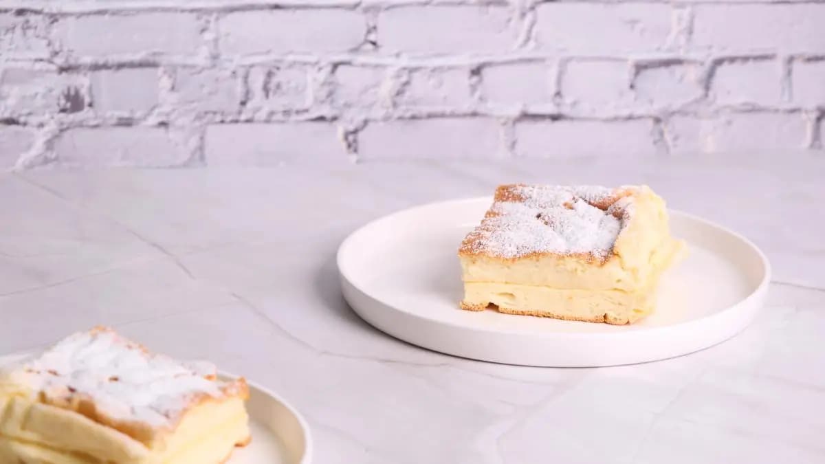 japonský cheesecake na talíři, který je pocukrovaný moučkovým cukrem japonský cheesecake na talíři, který je pocukrovaný moučkovým cukrem