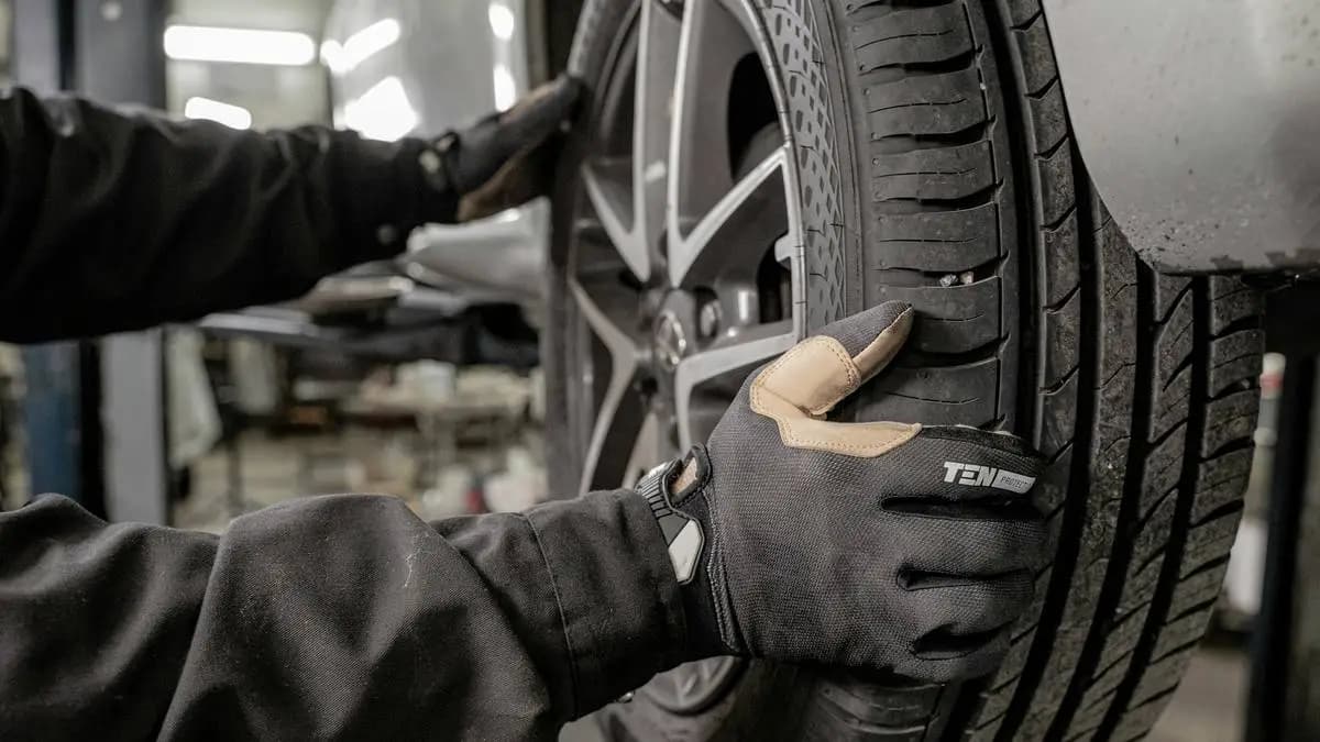 mechanik v dílně mění pneumatiky na vozidle mechanik v dílně mění pneumatiky na vozidle